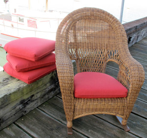 Large wicker chair with bright red seat cushion