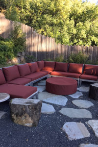 large outdoor patio couch with burgundy cushions and firepit cover