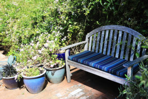 wooden bench with blue striped seat cushion