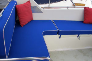 Bright blue sunbrella deck cushons with red pillow