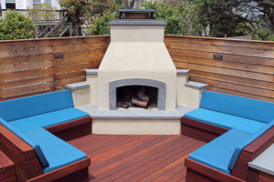 bright blue long bench cushions around outdoor fireplace