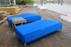 Patio furniture in back yard with tailored blue canvas covers on chaise